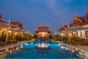 una piscina en un complejo por la noche en RaVorn Villa Boutique, en Battambang