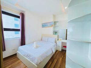 a small bedroom with a white bed and a window at My Khe Beach Ocean Opus Apartments in Da Nang +68 photos