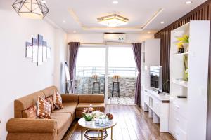 a living room with a couch and a table at My Khe Beach Ocean Opus Apartments in Da Nang