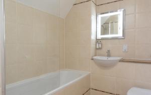 a bathroom with a bath tub and a sink at Heacham Manor Hotel in Hunstanton