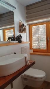 une salle de bains avec lavabo, toilettes et miroir dans l'établissement Stay Novy, à Bach 57 autres photos