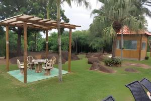 a pavilion with a table and chairs in a yard at Linda casa em Indaiatuba (Interior de SP) in Francisco Quirino