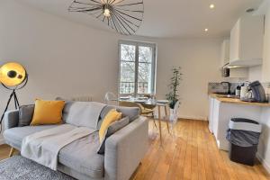 ein Wohnzimmer mit Couch und Küche in der Unterkunft Le Cocon des halles * Ideal Couple ou solo * WiFi * Élégance * Pieds des Halles in Troyes + 18 Fotos