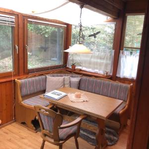 a dining room with a table and a couch at Authentiek, Vintage Chalet aan de Bosrand in Weyer