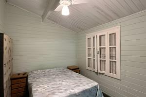 a bedroom with a bed and a ceiling fan at Linda Casa em Juquehy - SP (3) in São Sebastião +49 photos
