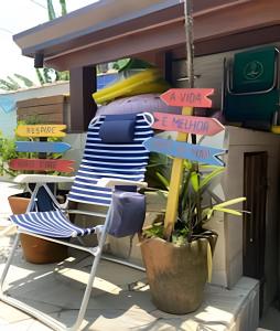 ein Stuhl und Straßenschilder vor einem Haus in der Unterkunft Linda Casa Piscina no Sertão de Cambury - SP (2) in Camburi