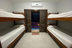 ein Zimmer mit drei Etagenbetten und einem Flur in der Unterkunft Linda Casa Piscina no Sertão de Cambury - SP (2) in Camburi + 38 Fotos