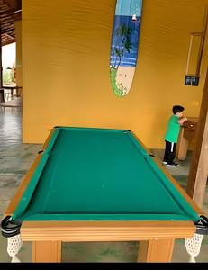 a man standing next to a pool table at Linda casa em Boiçucanga (Litoral Norte SP) in Boicucanga