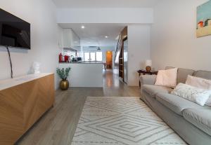 ein Wohnzimmer mit Couch und Küche in der Unterkunft Casinha da Rita by Home Sweet Home Aveiro in Aveiro