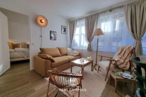 a living room with a couch and a table at La Symphonie Elevator Honfleur City Center 2 Guests in Honfleur