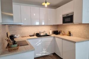 a kitchen with white cabinets and a counter top at La Symphonie Elevator Honfleur City Center 2 Guests in Honfleur +8 photos