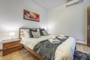 グジラにあるLarge & Modern 3BR Seafront Apartment with Large Balcony - Close to Saint Julian's, Sliema, & Manoel Islandの大きなベッドと枕のある寝室