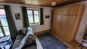 a living room with a couch and a cabinet at Ferienwohnung Osser Woid in Lohberg