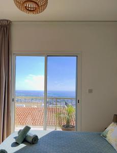 a bedroom with a bed and a view of the ocean at Green Oasis Penthouse in Peyia +34 photos
