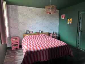 a bedroom with a bed with a red and white blanket at Idéal 24H du Mans - 3 chambres, jardin & stationnement facile in Saint Pavace