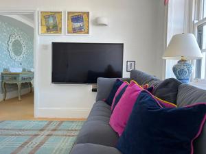 a living room with a couch and a tv at Broadstairs Beach Holiday Apartments, self-catering seafront stays at Kingsgate Bay, with parking space in Broadstairs +52 photos