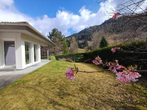 dom z ogrodem z różowymi kwiatami w obiekcie Falcon Lodge Kaprun Kitzsteinhorn - Steinbock Lodges w Kaprunie