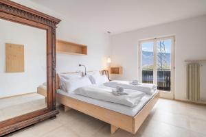 a bedroom with a large mirror and a bed at Pool Apartments Edith in Lana