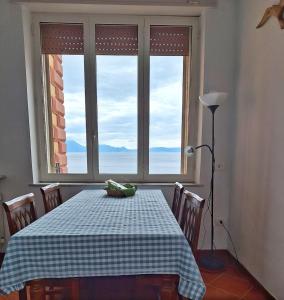 a dining room table with a checkered table cloth and a window at Casa Parthenope, a window on the sea in Naples
