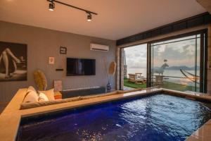 a swimming pool in a living room with a large window at Villa Lada Slav in Kızılcakaya
