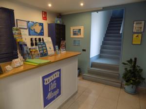 a waiting room with a counter and a flight of stairs at Hostal Villa Maruja in El Arenal