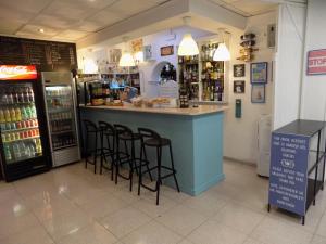 a bar in a store with stools at a counter at Hostal Villa Maruja in El Arenal
