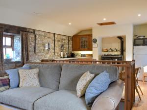 a living room with a couch and a kitchen at The Cottage At Wilson House in Rokeby