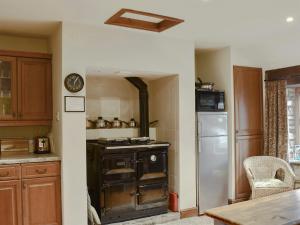 a kitchen with an old stove and a refrigerator at The Cottage At Wilson House in Rokeby