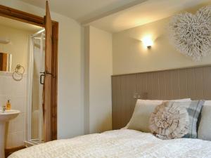 a bedroom with a bed and a bathroom with a sink at The Cottage At Wilson House in Rokeby +5 photos