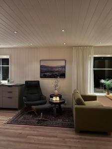 a living room with two chairs and a table at Bella Karnes in Oksevik +61 photos