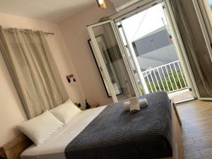 a bedroom with a bed and a large window at Zante Art de l'eau in Zakynthos