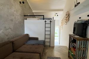 a room with a couch and a bunk bed at Lindo Flat na Praia Barra do Una in Barra do Una