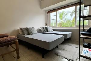 a bedroom with two beds and a window at Lindo Flat na Praia Barra do Una in Barra do Una +16 photos