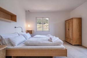 a bedroom with a large white bed with a window at Pool Apartments Edith in Lana +66 photos