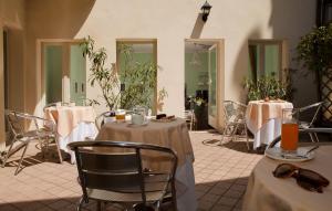 a dining room with tables and chairs and mirrors at Albergo Orologio in Brescia