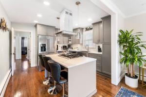 eine Küche mit weißen Schränken und eine Insel mit Barhockern in der Unterkunft Suburban 3BR Stylish Oasis in Maplewood