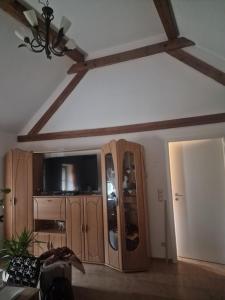 sala de estar con TV y armarios de madera. en Ferienwohnung Zur Flomborner Wutz, en Flomborn 9 fotos más