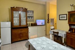 a kitchen with a dining table and a refrigerator at Il Barbagianni in Chieuti