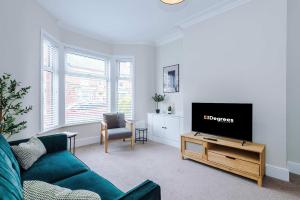 a living room with a couch and a flat screen tv at Spacious & Modern House in Crewe by 53 Degrees Property, Ideal for Long Term, Sleeps 8! in Crewe