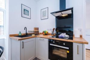 a kitchen with a sink and a stove top oven at Spacious & Modern House in Crewe by 53 Degrees Property, Ideal for Long Term, Sleeps 8! in Crewe