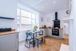 a kitchen with a table and chairs in a room at Spacious & Modern House in Crewe by 53 Degrees Property, Ideal for Long Term, Sleeps 8! in Crewe