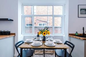 a table with a vase of flowers on top of it at Spacious & Modern House in Crewe by 53 Degrees Property, Ideal for Long Term, Sleeps 8! in Crewe +26 photos