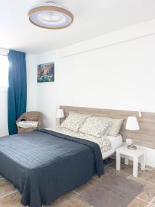 a bedroom with a large bed with a blue blanket at Copacobana Ocean View Playa Las Americas in Costa de Adeje +37 photos