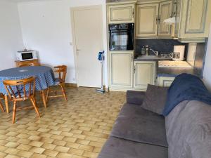 a living room with a couch and a table and a kitchen at La Cabane Mayotte in Cucq