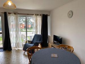 a room with a table and chairs and a window at La Cabane Mayotte in Cucq