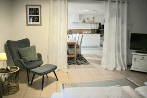 a living room with a chair and a television at Apartment Souterrain Bühl Vimbuch Familie Bork in Bühl