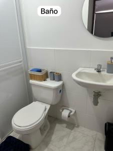 a white bathroom with a toilet and a sink at Apartamento Mirador del Valle in Valledupar