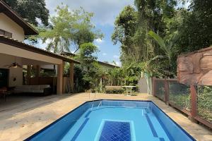 a swimming pool in the backyard of a house at Bela casa em Riviera – SP (6) in Bertioga