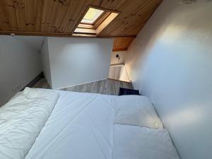 a bed in a small room with a window at Triplex au cœur de Le Palais avec Wifi, près de la plage - FR-1-418-261 in Le Palais