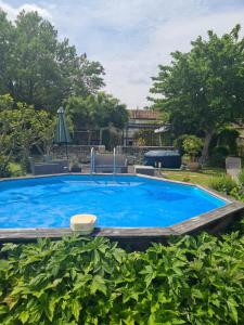 a large blue swimming pool in a yard at Jasmine cottage in Prinçay